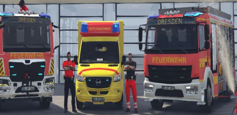 Zwei Löschfahrzeuge und ein Rettungswagen der Berufsfeuerwehr Dresden vor der Fahrzeughalle, davor zwei Einsatzkräfte